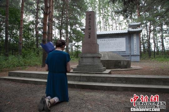 一名日本遗孤跪拜在中国养父母公墓前于琨摄